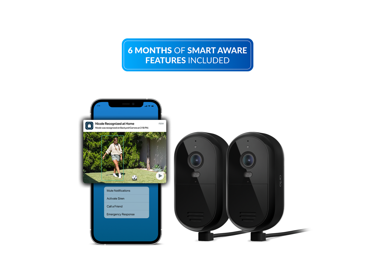 Two Essential Plug in security cameras shown beside a smartphone mockup displaying a home security app screen, with a blue banner at the top reading '6 MONTHS OF SMART AWARE FEATURES INCLUDED' on a white background.